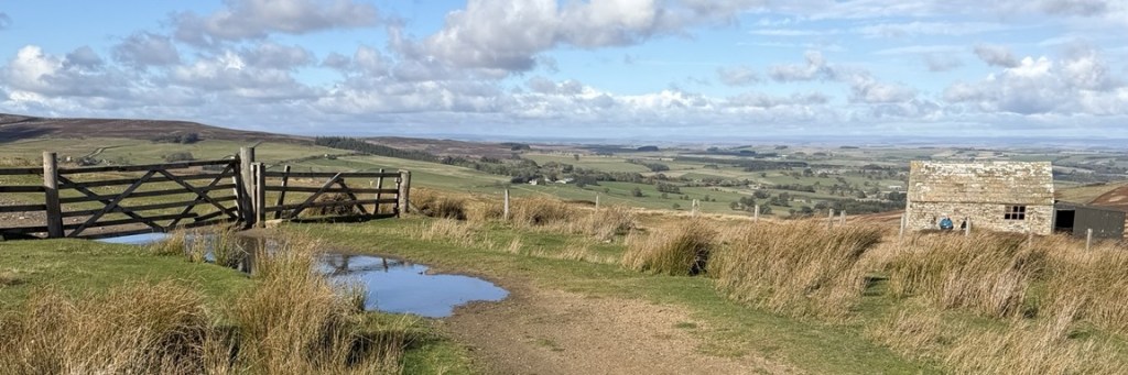 Northumberland trail and countryside beneath a bright blue sky