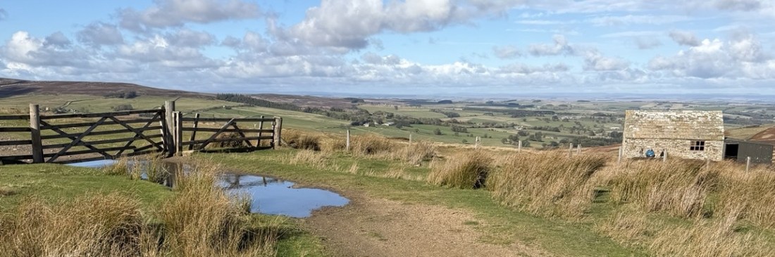 Northumberland trail and countryside beneath a bright blue sky